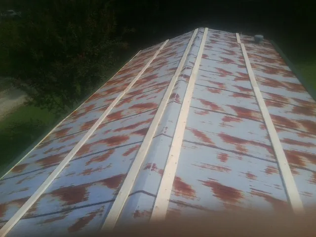 Rusted metal roof panels with new wood purlins before replacement — Storm Damage Roof Repair in Patrick by Roofing Brothers