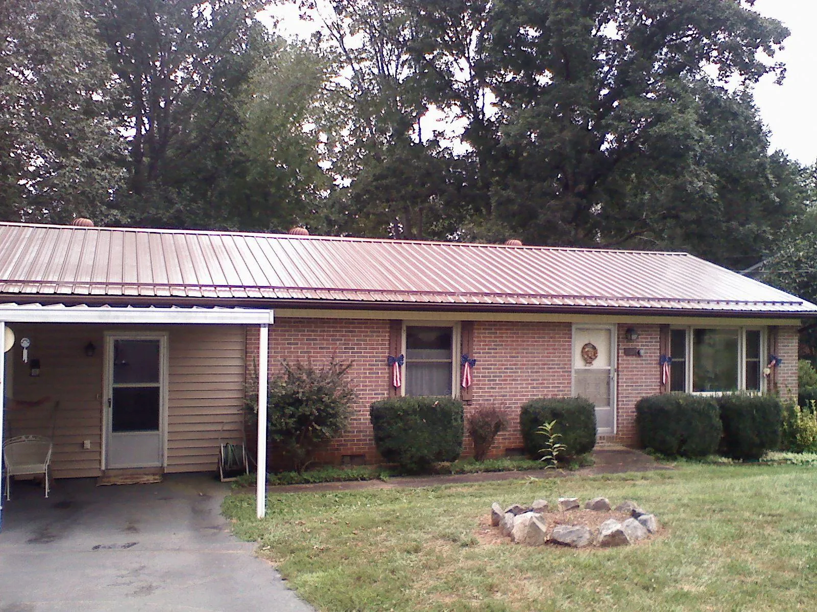 Bronze metal roof and carport on a brick ranch home — Roof Repair work by our crew in Patrick
